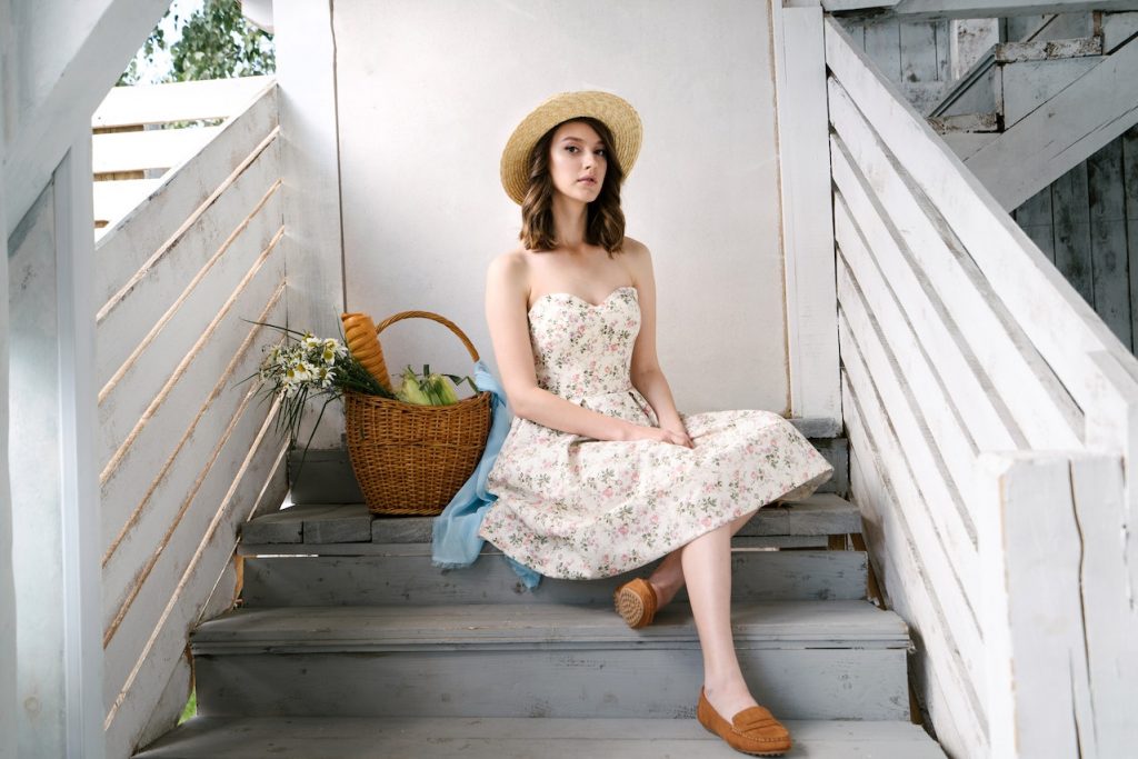 une femme portant une combinaison vert olive retro assise sur des escaliers