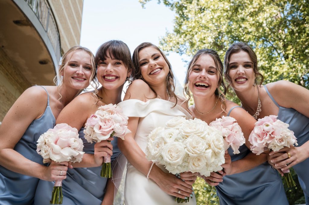 un groupe de jeune femmes habillées en robe de mariée champêtre grande taille, et qui célébre le mariage de leur copine