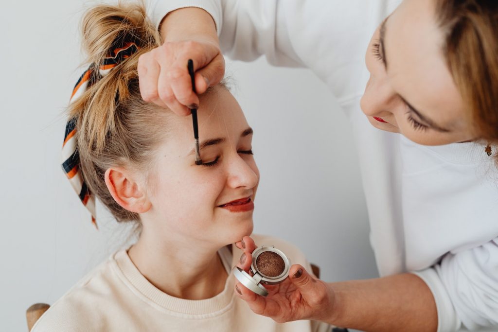 une femme qui fait du maquillage a une autre femme