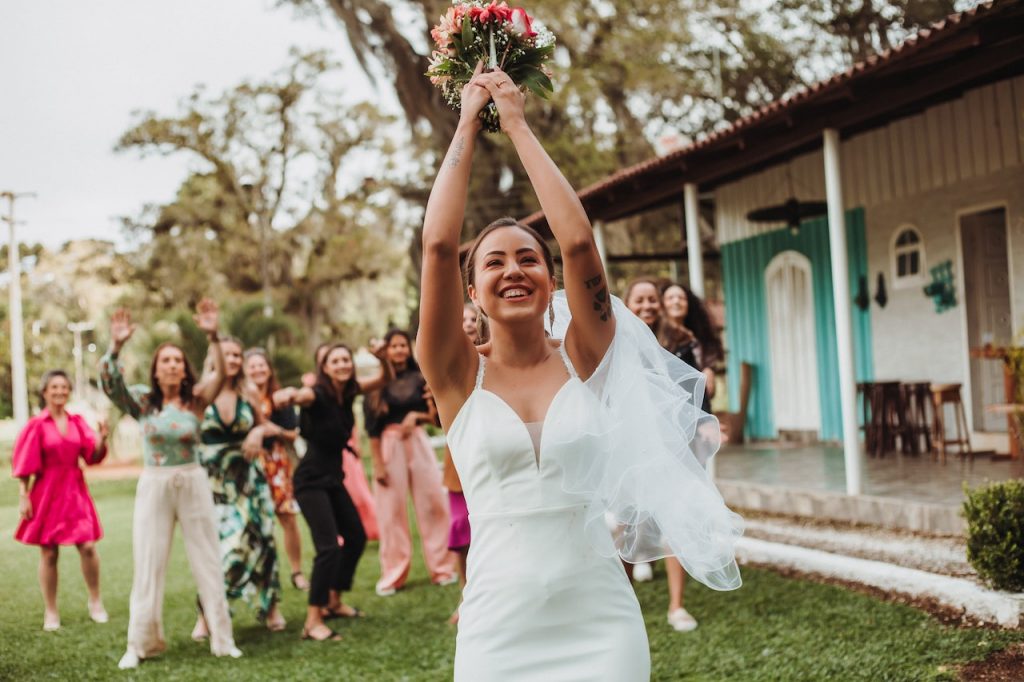 une marriée est sur le point de lancer un bouquet de fleurs à ses démoiselles d' honneurs