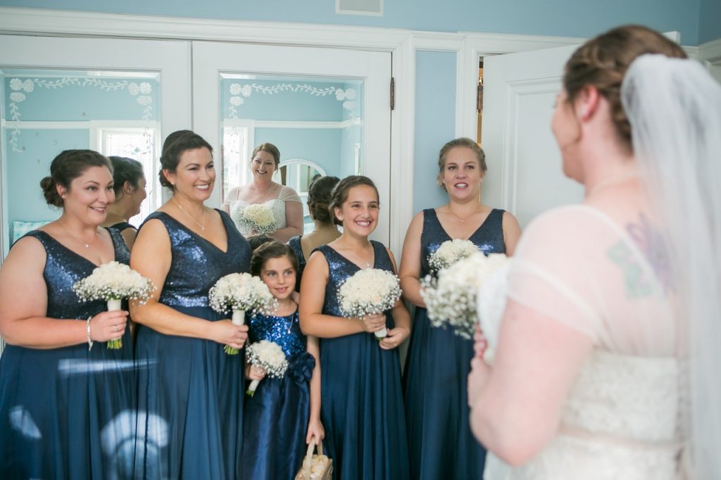 une mariée qui porte une robe pour mariage grande taille, devant ses demoiselles d'honneur